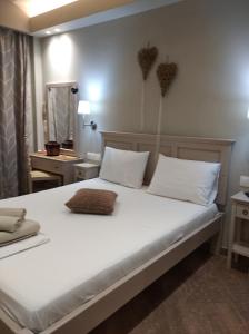 1 dormitorio con 1 cama blanca grande con almohadas blancas en Maltezos Rooms en Methana