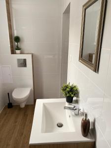 ein weißes Bad mit einem Waschbecken und einem WC in der Unterkunft Apartamenty ToTuGdynia 6 in Gdynia