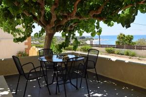 a table and chairs on a patio with a tree at Pasithea in Frangokastello