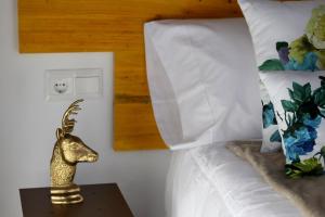 ein Bett mit einem goldenen Hirschkopf auf einem Nachttisch in der Unterkunft Urban Hipster 2 in Málaga + 20 Fotos