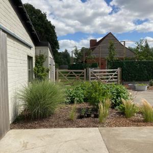 un jardín con plantas en un patio junto a una casa en Holiday home De Levensgenieter, en Torhout