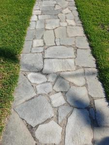 a stone path in the grass in a yard at Hotel Ermioni in Kalamitsi