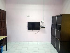 a living room with a tv on a white wall at Homestay Roomstay Muar Srizahrani in Muar