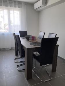 a dining room table with chairs and a laptop on it at Le coin des Oliviers in Puget-sur-Argens