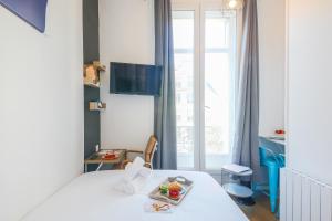 a room with a bed with a tray of food on it at Apartments WS Haussmann - La Fayette in Paris