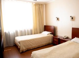 En eller flere senge i et værelse på Hotel Alma-Ata