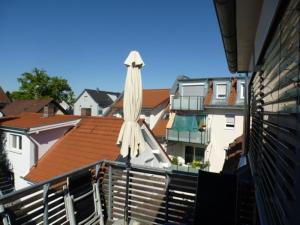 ラドルフツェル・アム・ボーデンゼーにあるFerienwohnung Casa Bluのバルコニーの上に座る閉傘