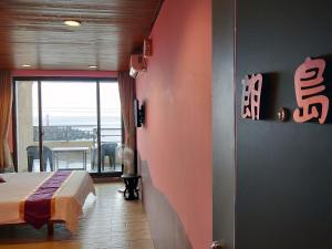 a bedroom with a bed and a view of the ocean at Two Fish Homestay in Lanyu