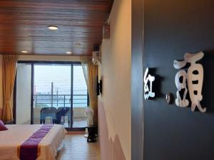 a bedroom with a bed and a view of the ocean at Two Fish Homestay in Lanyu