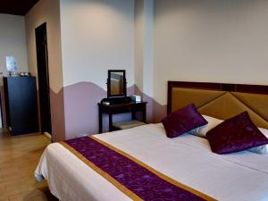 a bedroom with a bed and a tv on a table at Two Fish Homestay in Lanyu