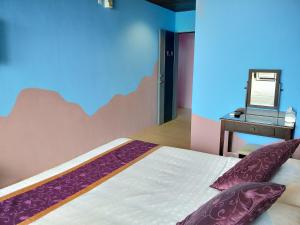 a bedroom with a bed and a table with a mirror at Two Fish Homestay in Lanyu