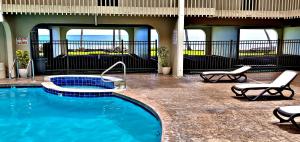 a swimming pool in a hotel with two lounge chairs and a pool at Ali'i Banyan Breeze in Kailua-Kona