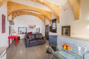 ein Wohnzimmer mit einem Sofa und einem Glastisch in der Unterkunft Valletta Harbour View Apartment in Valletta