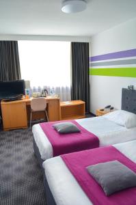 a hotel room with two beds and a television at ibis Styles Bielsko Biala in Bielsko-Biała
