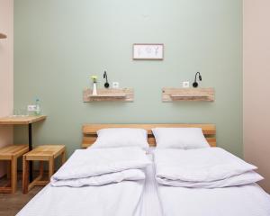 2 Betten in einem Zimmer mit einem Tisch in der Unterkunft DREAM Hostel Khmelnytskyi in Chmelnyzkyj