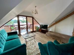 a room with a bed and chairs and a television at VILLA ANGEL in Rožňava