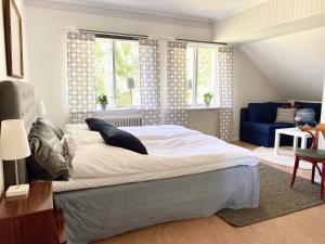 1 dormitorio con 1 cama grande y 1 sofá azul en Sörbygården Bed & Breakfast, en Brunflo