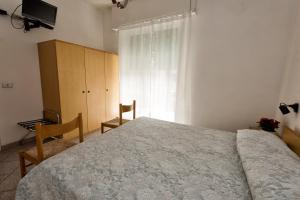 a bedroom with a bed and a dresser and a window at San Francisco rooms in Marina di Andora +23 photos