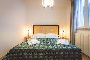 una camera da letto con un grande letto con due cuscini di Via Siena 4 - Suites & Rooms a Marina di Cecina