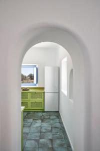 uma cozinha com um frigorífico branco e piso em azulejo em Villa Rodakes em Vourvoúlos