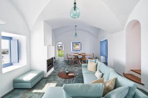 een woonkamer met een blauwe bank en een tafel bij Villa Rodakes in Vourvoúlos