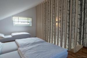 sypialnia z 2 łóżkami i oknem w obiekcie Domki Letniskowe AlexJan w mieście Dąbki