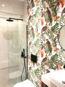 a shower in a bathroom with a wall mural of birds at Petrus Studio with balcony in Thessaloniki