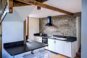 a kitchen with white cabinets and a black counter top at Borthwick Castle View in North Middleton