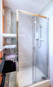 a shower with a glass door in a bathroom at Borthwick Castle View in North Middleton