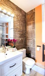 La salle de bains est pourvue de toilettes, d'un lavabo et d'un miroir. dans l'établissement Borthwick Castle View, à North Middleton