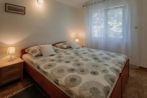 a bedroom with a large bed with a window at Apartmani Melem in Stari Grad