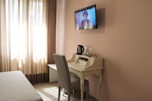 a room with a desk with a tv on the wall at L'Acchiappasogni Vesuviano Guest House in Portici