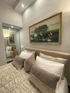 a bedroom with a bed with a painting on the wall at Lemon Suite in Kavala