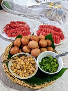 una mesa con platos de comida, huevos y hortalizas en วังผา ชาเล่ต์ รีสอร์ท, en Ban Fai Mun