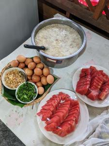 una mesa con platos de comida, huevos y carne en วังผา ชาเล่ต์ รีสอร์ท en Ban Fai Mun