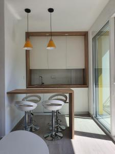 una cocina con 3 taburetes y una barra en Viola lux apartments, en Kotor