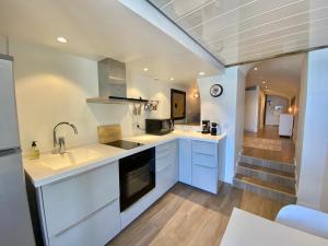 une cuisine avec des placards blancs et un escalier dans l'établissement Longue 1 Menton, à Menton