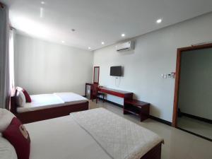 a hotel room with two beds and a flat screen tv at Thanh Lam Hotel in Tuy Hoa