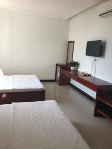 a hotel room with two beds and a tv at Thanh Lam Hotel in Tuy Hoa