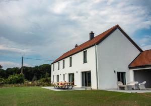 a white house with a picnic table in a yard at XXV House - 12 personnes in Héron