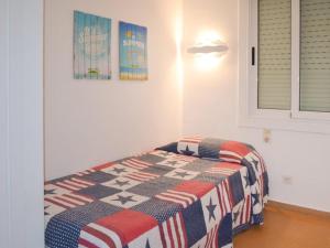 a bedroom with a bed with a quilt on it at Apartament Blue Lloret de mar in Lloret de Mar