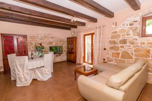 a living room with a couch and a stone wall at Casa Ghedda in Gedići