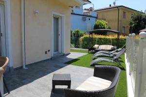 eine Terrasse mit einem Haufen Stühle und Tische in der Unterkunft Villa Martina in Desenzano del Garda