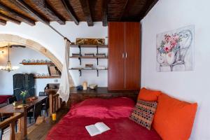ein Wohnzimmer mit einem roten Bett und einem Tisch in der Unterkunft 1900's traditional house in Asklipio in Asklipiḯon