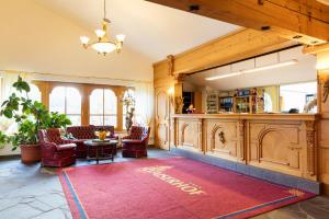 a living room with a red rug on the floor at Familotel Kaiserhof - Families only in Berwang