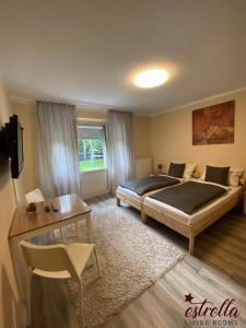 a bedroom with a bed and a table and a television at estrella24 LIVING ROOMS 87 Paris in Herne
