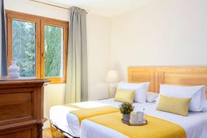a hotel room with two beds and a window at Genteel Home Alhacaba in Granada