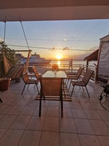 eine Terrasse mit einem Tisch und Stühlen sowie einem Kreuzfahrtschiff in der Unterkunft Elli's House in Keramotí