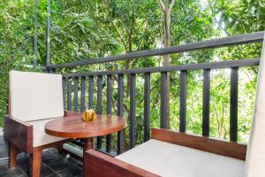 a table and chairs on a balcony with trees at Won Residence & Spa in Siem Reap