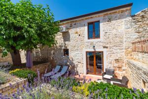 a stone house with a garden in front of it at Casa Ghedda in Gedići